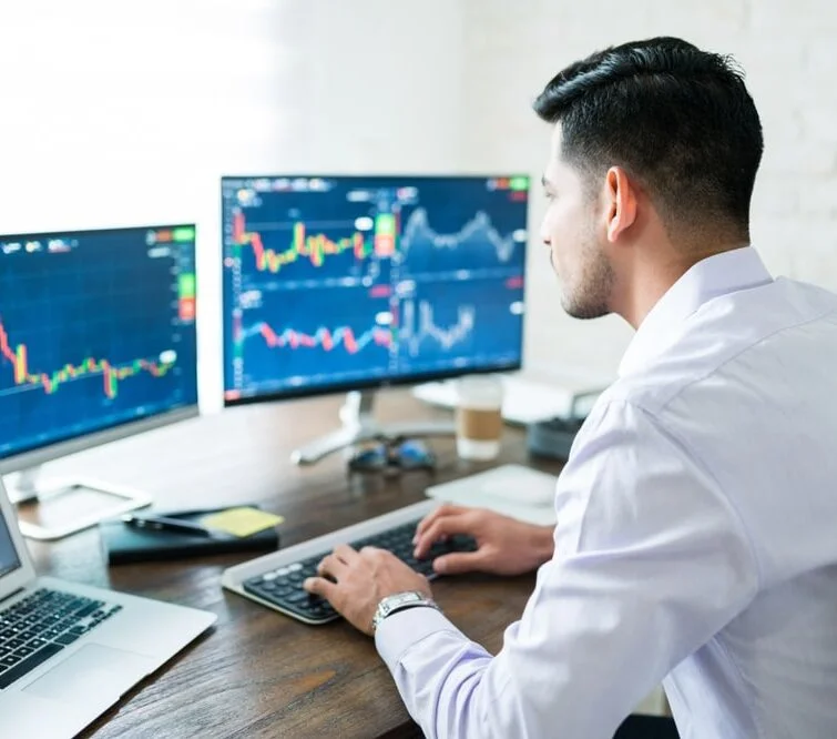 Een man aan een computer analyseert grafieken
